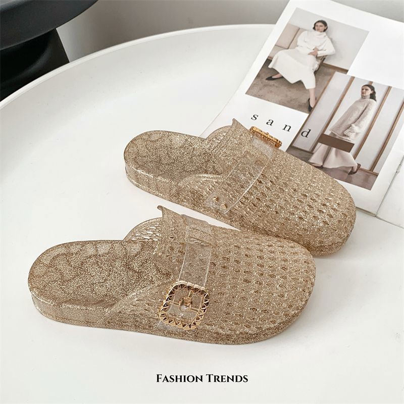 Gold translucent crystal buckle mules on a light table